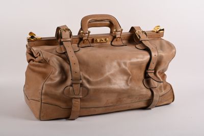 sac à main en cuir marron sur fond blanc, avec des anses dorées
