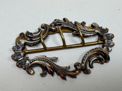 une broche ancienne en argent et or, ornée d'un motif décoratif