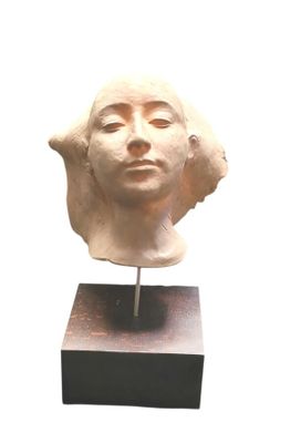 sculpture d'une tête de femme sur une base en bois