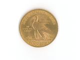 a gold coin with a bird on it on a white surface