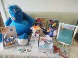 a blue stuffed animal sitting next to a pile of toys