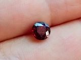 quelqu'un tient une pierre de grenat rouge dans la main
