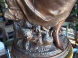 bronze statue of a woman and her dog on a pedestal
