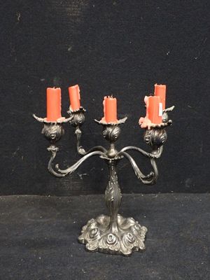 un candélabre en argent sur lequel sont disposées des bougies orange