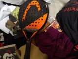 a close up of a tennis racket and other items on a bed