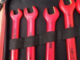 five red wrenches in a black case on a table