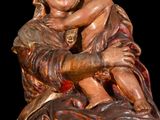 wooden statue of a woman holding a child on her lap