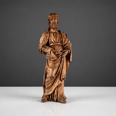 une statue en bois représentant un homme tenant un livre