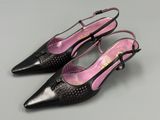 a pair of black and pink shoes on a gray surface