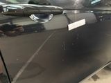 a black car with a sticker on it parked in a parking lot