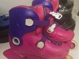 several pairs of pink and purple skates sitting on top of a table