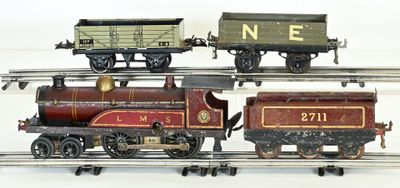 trois petits trains miniatures sur un circuit de train posé sur une surface blanche