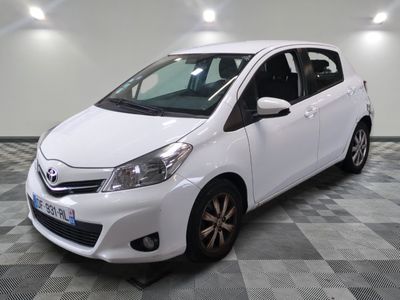 the white toyota yaris is parked on a checkered tile floor