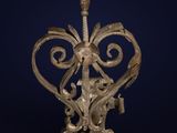 an old iron lamp with a decorative design on a dark blue background
