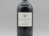 une bouteille de vin posée sur une table blanche