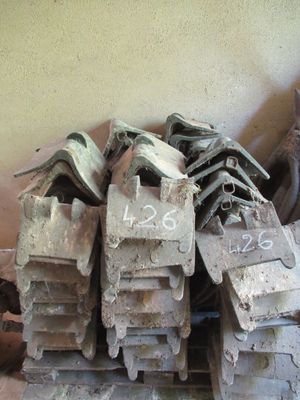 a pile of old shoes sitting on top of a pile of bricks