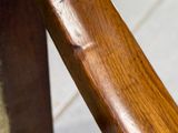 un gros plan d'une chaise en bois avec une assise en bois