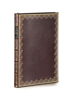 a brown leather book with gold trimming and a decorative border