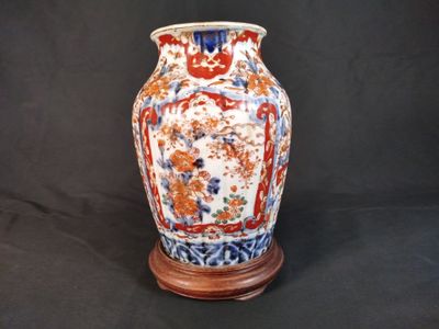 un vase posé sur un socle, sur fond noir