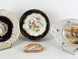 three plates and a heart shaped box are sitting on a table