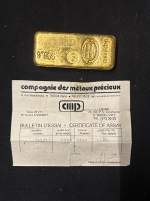 a picture of a gold bar and a certificate on a black background