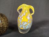 two vases sitting next to each other on a black surface