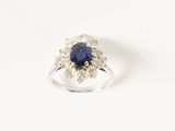 gros plan d'une bague avec un saphir et des diamants