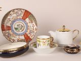 many different types of tea cups and saucers on the table