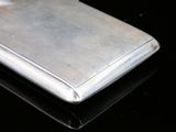 a silver cell phone sitting on a black surface