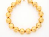 a gold beaded necklace on a white background