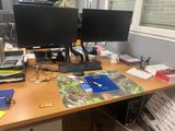 a desk with two computer monitors and a keyboard on it
