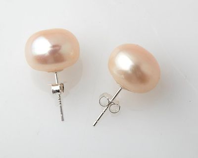 a pair of pink pearl earrings on a white surface