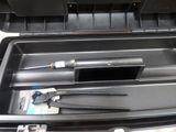a black box with a knife, scissors, and other items in it
