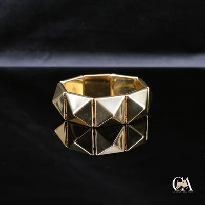 gros plan d'une bague en or sur une surface noire