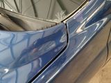 a close up of a blue car with a broken door handle
