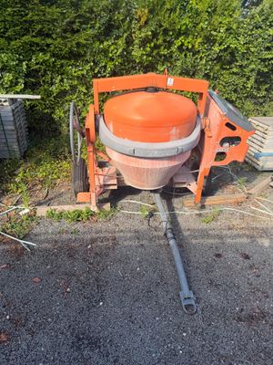 une bétonnière orange garée sur le bord de la route