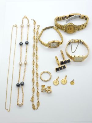 a group of gold and silver jewelry including a watch, bracelets, and rings