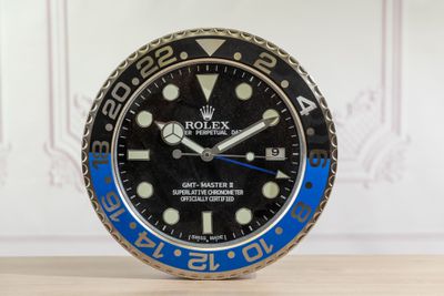 une montre Rolex noire et bleue posée sur une table