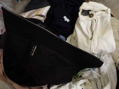 une valise remplie de vêtements posée sur un lit