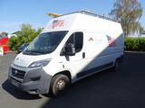 une camionnette blanche garée sur un parking, avec un drapeau sur le toit