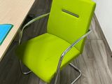 a green chair that is sitting in front of a desk