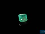 a green emerald stone on a black surface