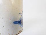 un vase bleu et blanc posé sur une surface blanche