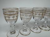 six wine glasses are lined up in a row on a white surface