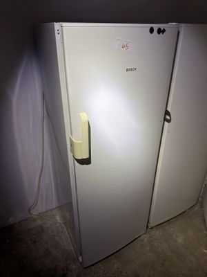 un réfrigérateur blanc dans le coin d'une pièce