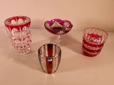 quatre vases en verre de couleurs différentes posés sur une table