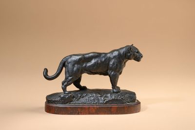 a bronze statue of a panther on a wooden base