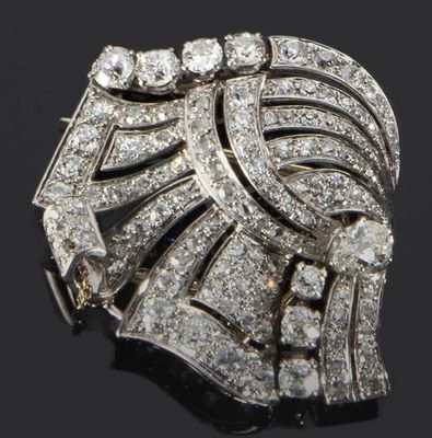 une image représentant une broche en forme de diamant posée sur une surface noire