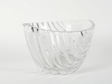 un saladier en verre transparent posé sur une surface blanche