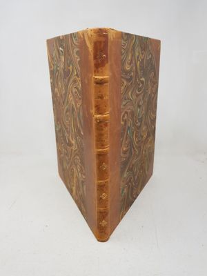 an old book sitting on top of a white table next to a white wall